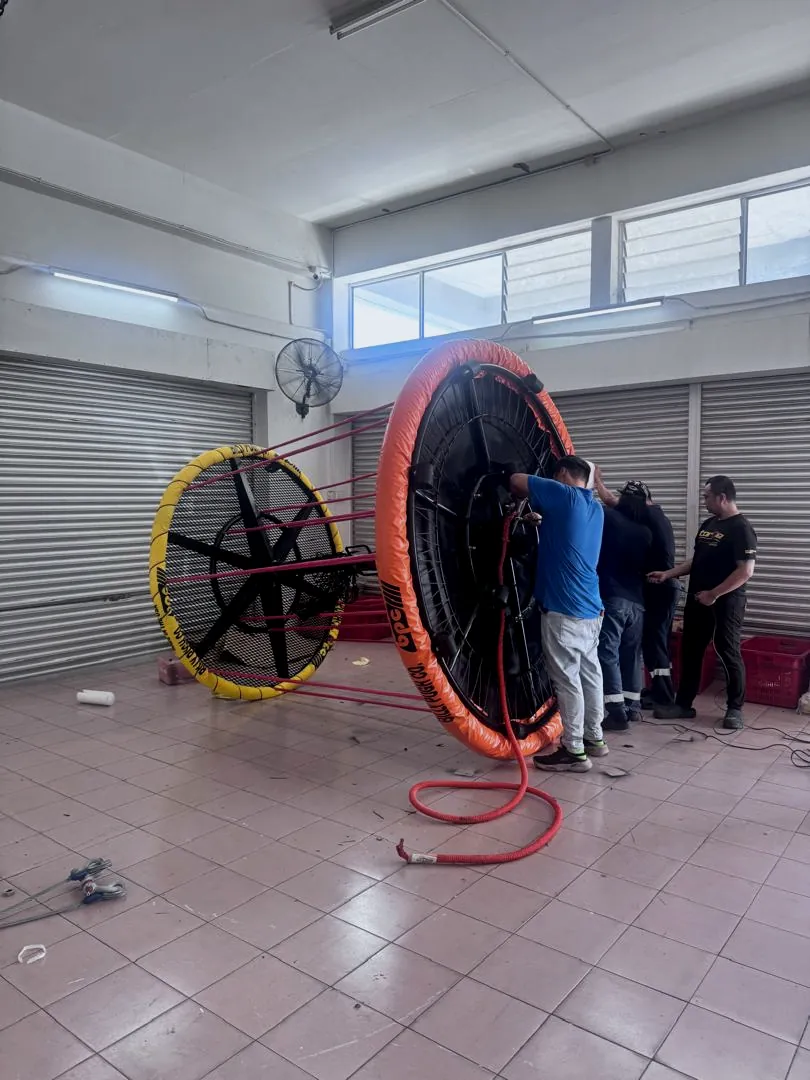 Era Harvest crew working on a personnel transfer basket laid on its side in a workshop
