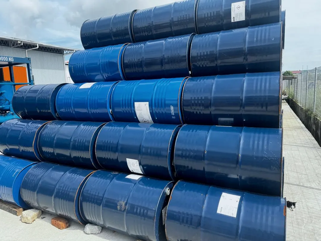 Blue chemical drums stacked in a yard