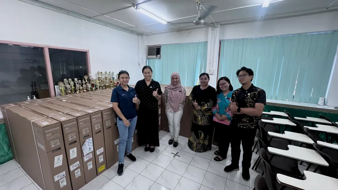 Era Harvest team handing over boxed smart TVs to school staff